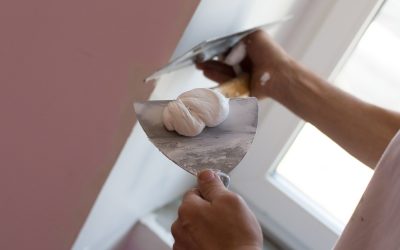 Craftsman skimming part of wall beside window.Home renovation concept