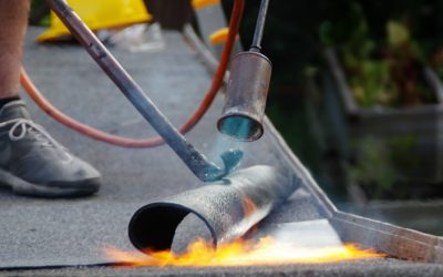 Roof house repair. Putting the roofing felt on the surface with a burner and fire.